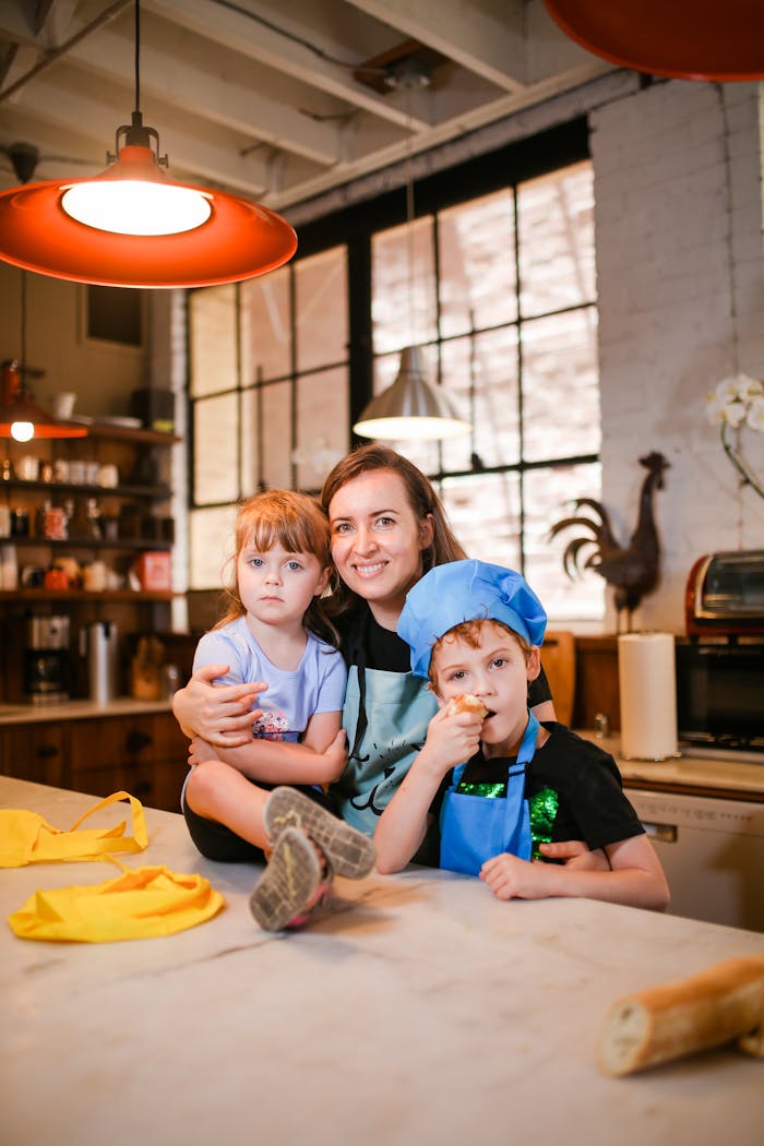 Mother with kids enjoying cooking time in a bright kitchen.