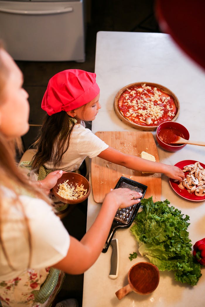 A mother and daughter enjoying quality time making homemade pizza in the kitchen.